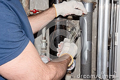 Plumber fixes water leakage in tubes Stock Photo