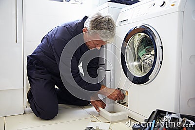 Plumber Fixing Domestic Washing Machine Stock Photo