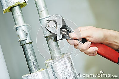 Plumber hand with wrench Stock Photo