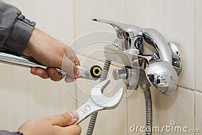 Plumber hands fixing water tap with spanner Stock Photo