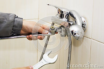 Plumber hands fixing water tap with spanner Stock Photo