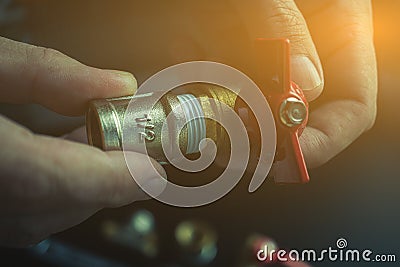 Plumber hands screwing nut of pipe over plumbing tools background. Concept of repair and technical assistance. Close up shot. Stock Photo