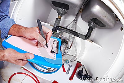 Plumber hands writing on clipboard. Stock Photo