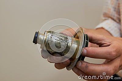 A man holds a broken pump part,the plumber holds a broken rotor of a circulation water pump in his hands Stock Photo