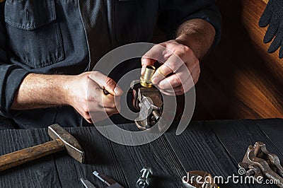 Plumber inserts the brass fittings into a vise. Close-up of a foreman hand while working in a workshop Stock Photo