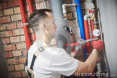 Plumber installing water equipment - meter, filter and pressure reducer Stock Photo