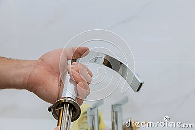 Plumber installing new mixer tap hands worker close up repair in bathroom at home Stock Photo