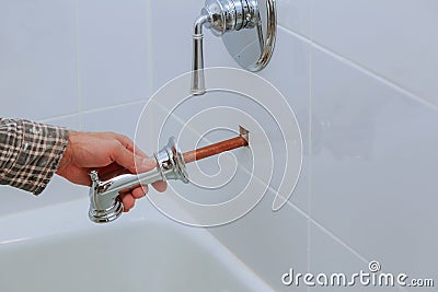 Plumber installing water faucet in the bathroom Stock Photo