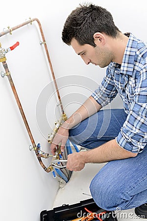 Plumber making adjustments to heating system Stock Photo
