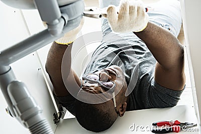 Plumber man fixing kitchen sink Stock Photo