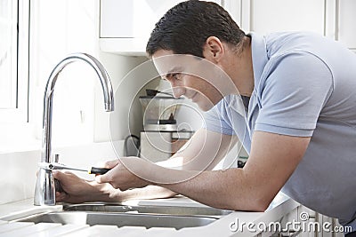 Plumber Mending Tap With Adjustable Wrench Stock Photo