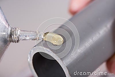 Plumber putting glue on a pvc pipe Stock Photo