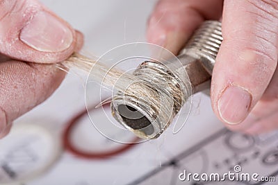 Plumber putting hemp fibers on a thread Stock Photo