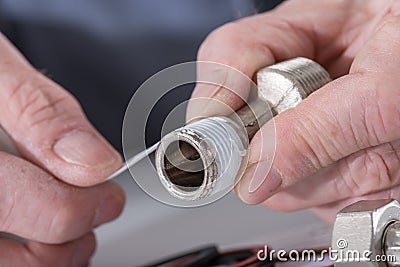 Plumber putting a teflon joint on a thread Stock Photo