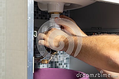 The plumber removes the blockage in the pipes Stock Photo