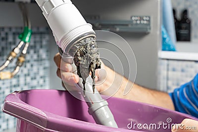 The plumber removes the blockage in the pipes Stock Photo