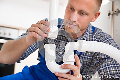 Plumber Repairing Pipe Of Sink Stock Photo