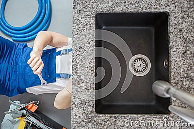 Plumber repairing pipes with wrench Stock Photo