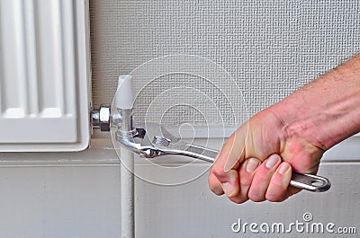 Plumber repairing a radiator pipe Stock Photo