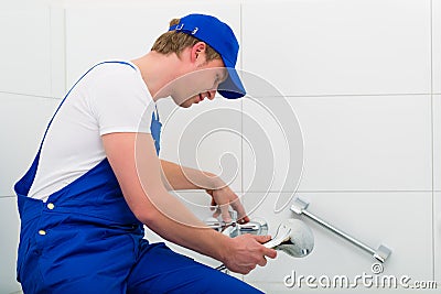 Plumber repairing shower in bath room Stock Photo