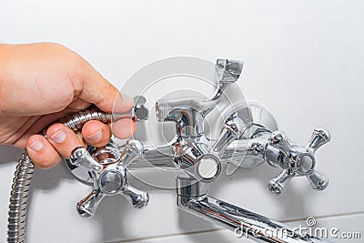 Plumber repairs a shower faucet in the bathroom. Stock Photo