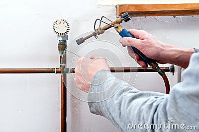 Plumber soldering pipe Stock Photo