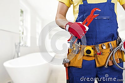 Plumber with tool belt standing in bathroom Stock Photo