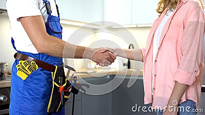 Plumber with tools shaking client hand, technical maintenance, repair services Stock Photo