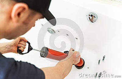 Plumber unclogging bathtub Stock Photo