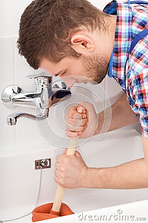 Plumber unclogging a bathtube drain Stock Photo