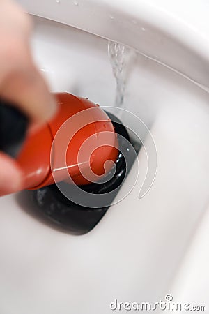 Plumber unclogging toilet Stock Photo