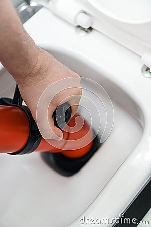 Plumber unclogging toilet Stock Photo