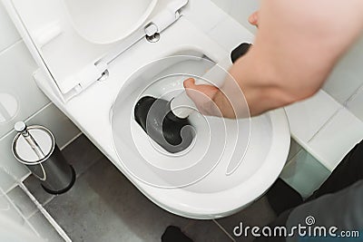 Plumber unclogging toilet Stock Photo