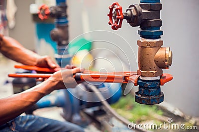 Plumber using a wrench to repair and remove the water supply pipe and valve Stock Photo