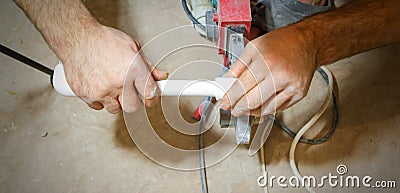 Plumber weld two pieces of white polypropylene pipes Stock Photo