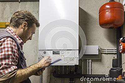 Plumber who carries out the maintenance of a condensing boiler Stock Photo