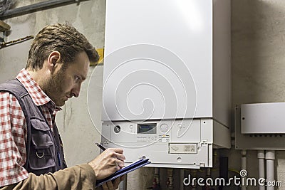 Plumber who carries out the maintenance of a condensing boiler Stock Photo