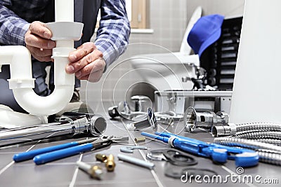 Plumber at work in a bathroom, plumbing repair service, assemble Stock Photo