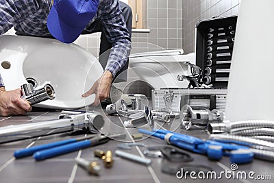 Plumber at work in a bathroom, plumbing repair service, assemble Stock Photo