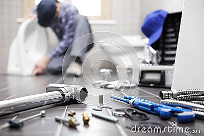 Plumber at work in a bathroom, plumbing repair service, assemble Stock Photo