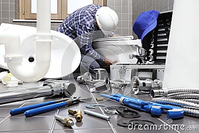 Plumber at work in a bathroom, plumbing repair service, assemble Stock Photo