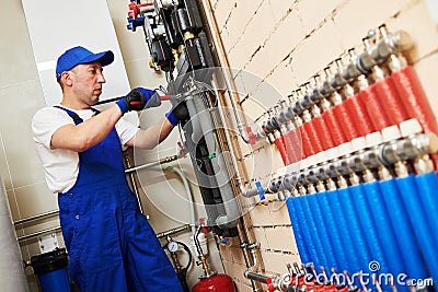 Plumber work. Installing collector for warm water underfloor heating system Stock Photo
