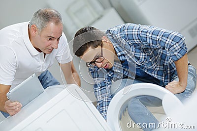 Plumbers repairing washing machine Stock Photo