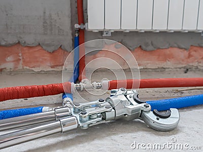 Plumbing copper pipe crimper press tube tool. Heating pipes connected by press fittings. Hydraulic, tools for plumber. Stock Photo