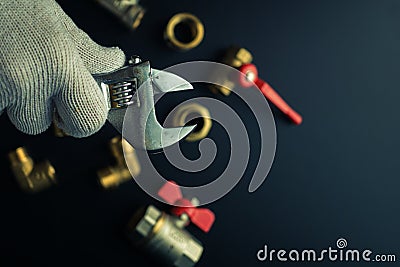Plumbing equipment on a black background. Valves and wrench Stock Photo