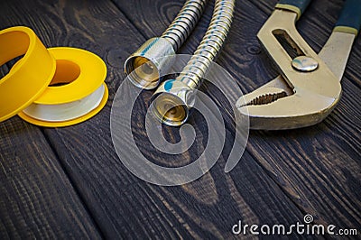 Plumbing tools for connecting water hoses on a black wooden background Stock Photo