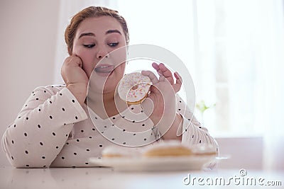 Plump young woman forgetting about all prohibitions Stock Photo