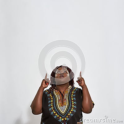 Plump young woman pointing fingers to heaven Stock Photo