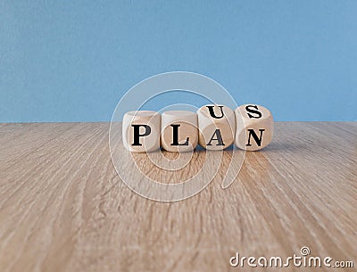 Plus, plan. Turned wooden cubes with words plus plan. Beautiful blue background,wooden table. Copy space. Business and plus plan Stock Photo