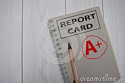 A plus - Report Card write on a book isolated on Office Desk Stock Photo